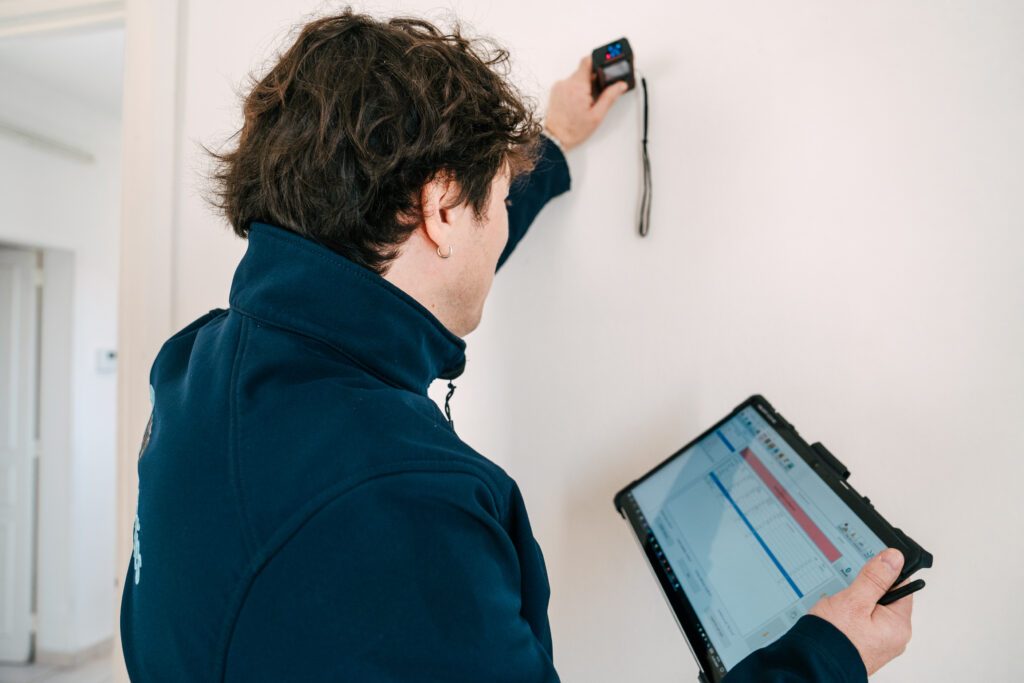 Diagnostiqueur effectuant une mesure lors d’un audit énergétique avec tablette et télémètre – BTP Diagnostics