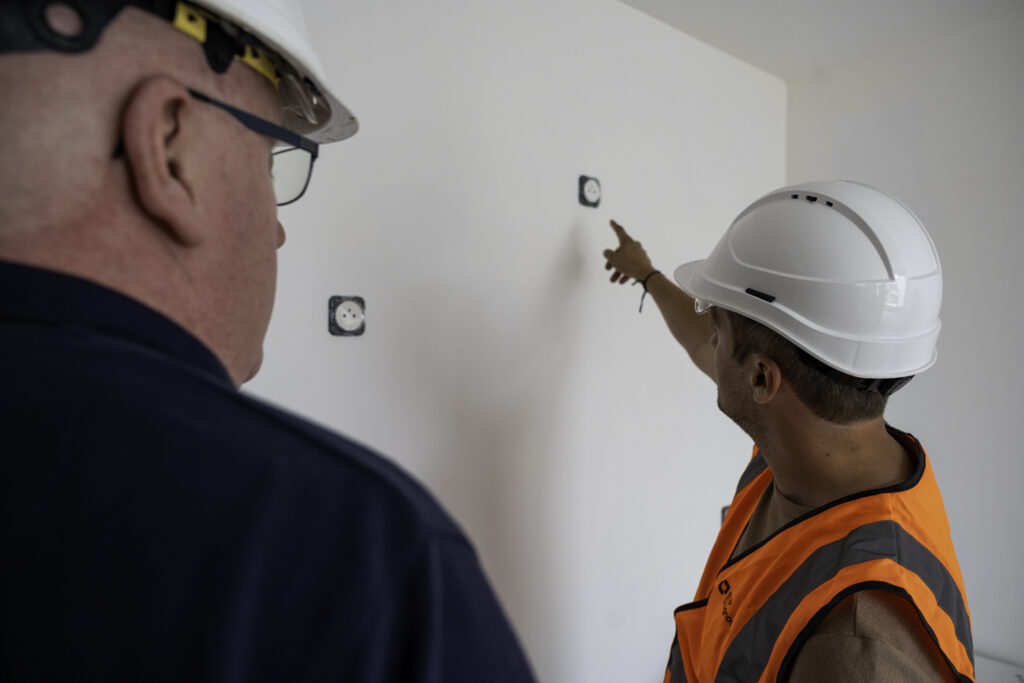 Technicien réalisant un diagnostic électrique dans un logement