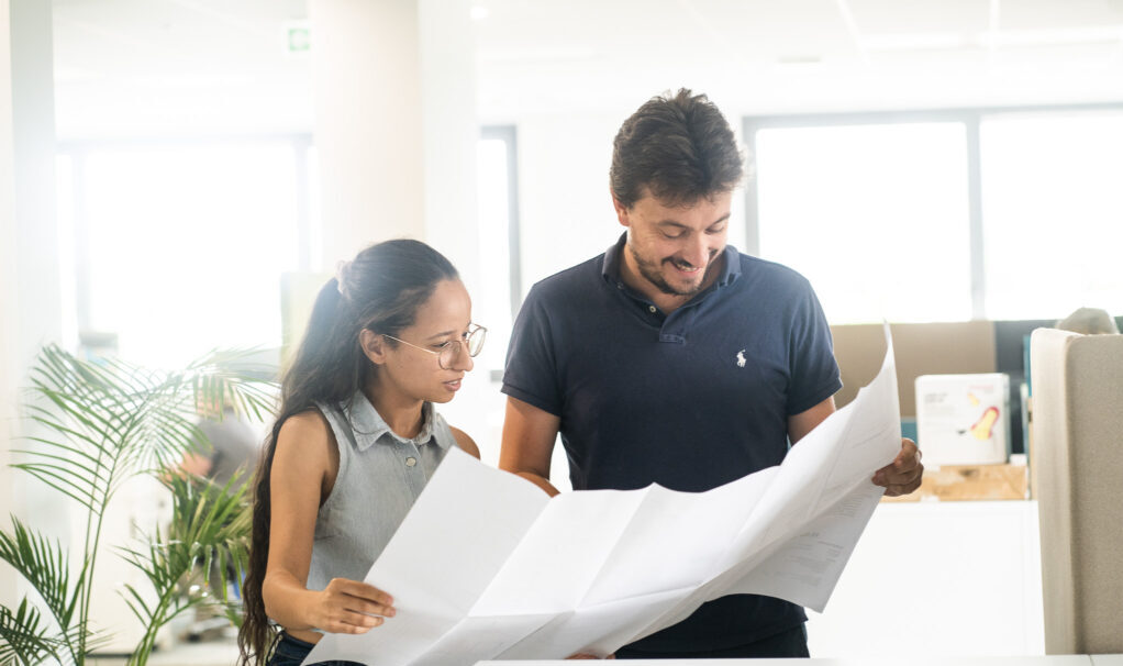 Deux collaborateurs consultant des documents dans un bureau