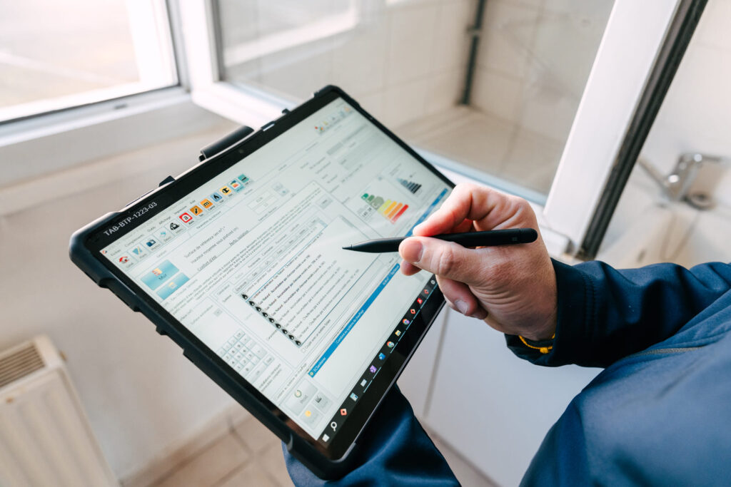 Diagnostiqueur certifié réalisant un audit énergétique sur tablette – BTP Diagnostics